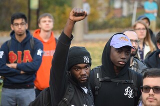 A student holds a raised fist in the air as he protests president-elect Donald Trump and his campaign rhetoric. 